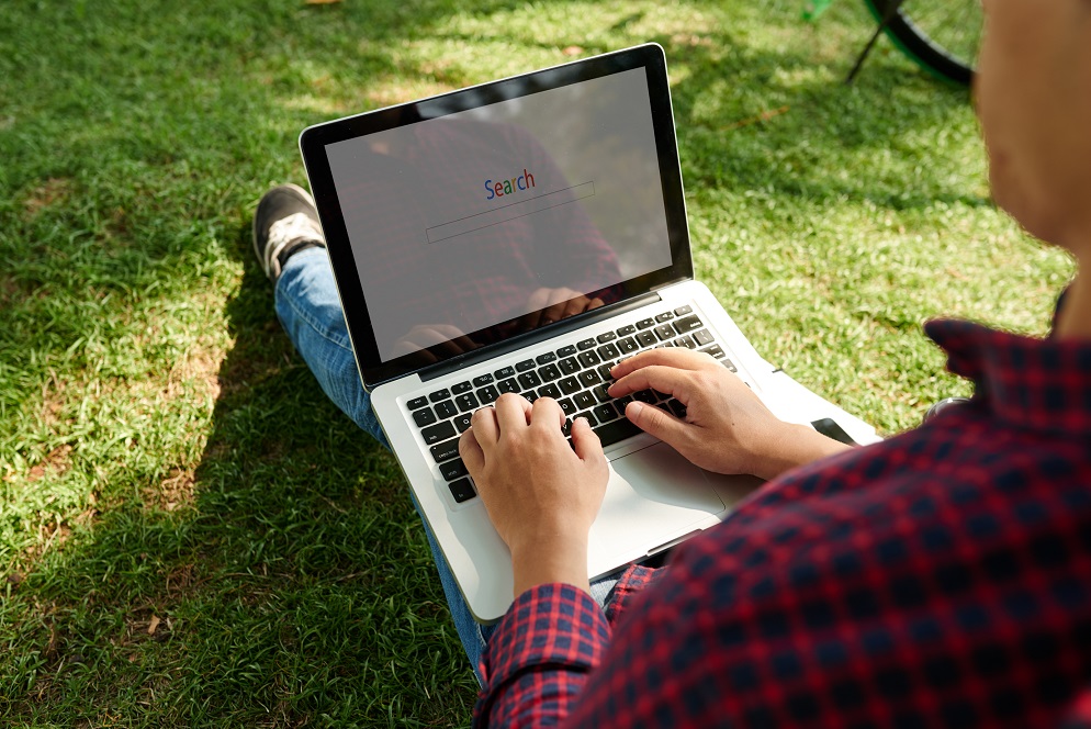 Man sitting outdoors and searching information on internet